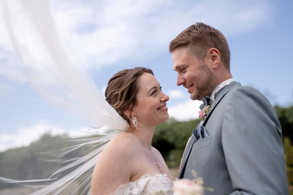 Brautpaar blickt sich bei der Hochzeit auf Schloss Hundisburg lächelnd an